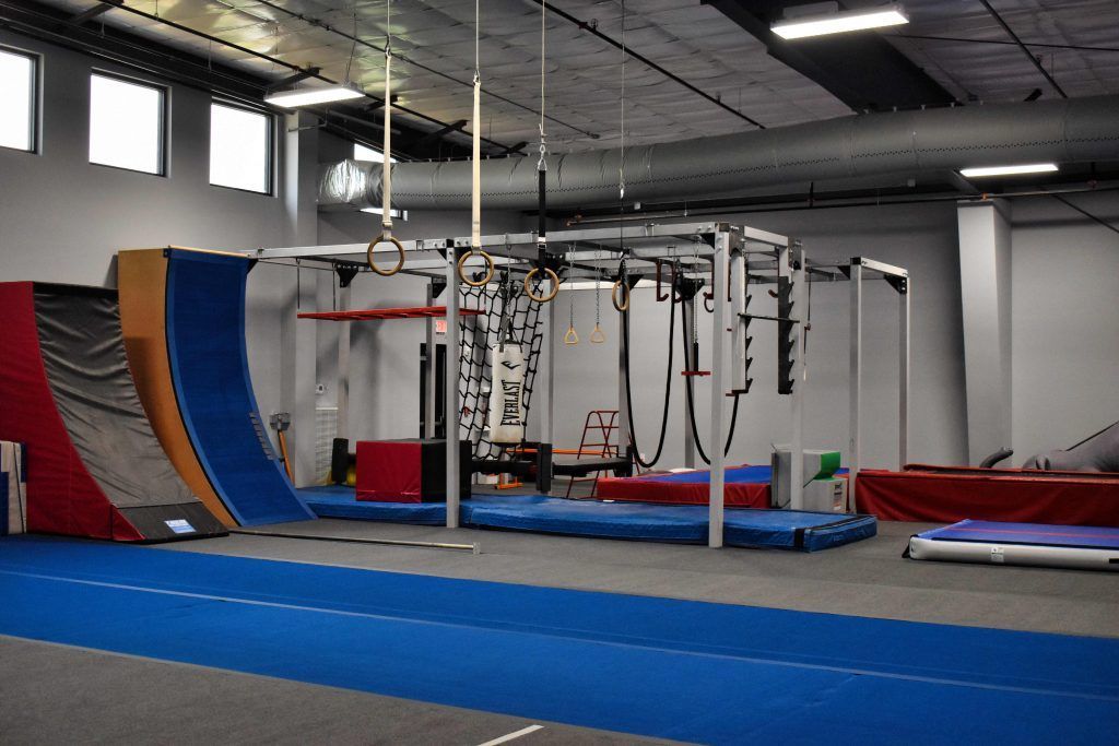 A gym filled with a variety of exercise equipment and a blue mat.