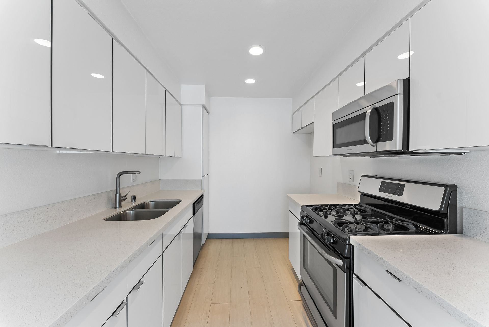 Sliding Photo Gallery Displaying Apartment Features- White kitchen with black appliances