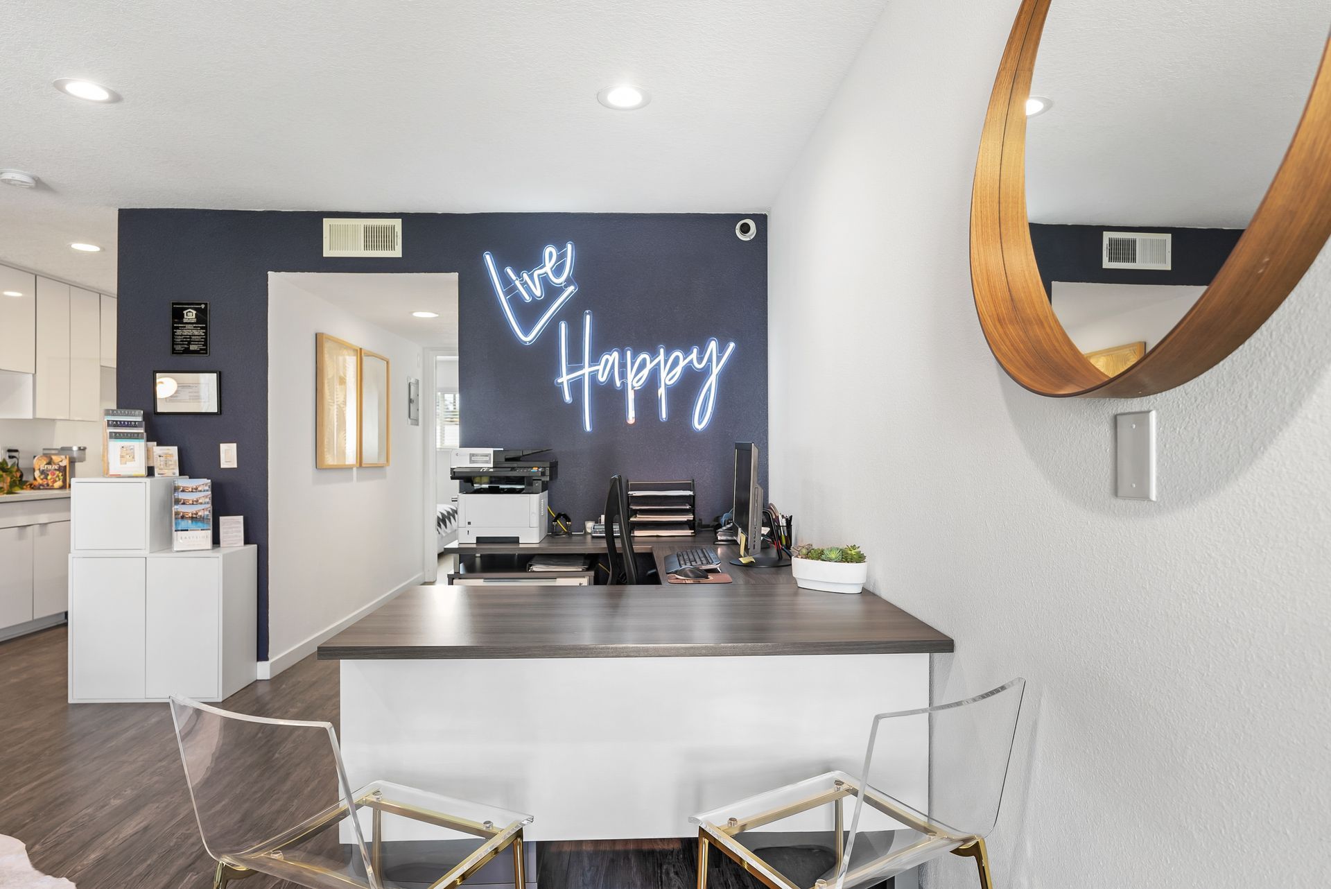 Interior leasing office with desk and neon Live Happy sign