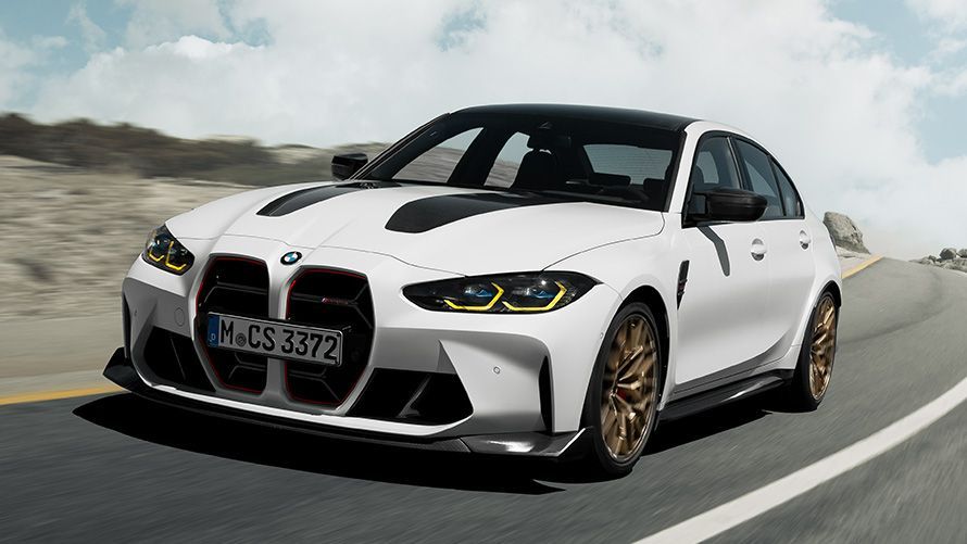 White BMW M3 sedan on a road, black hood, gold wheels, front view.