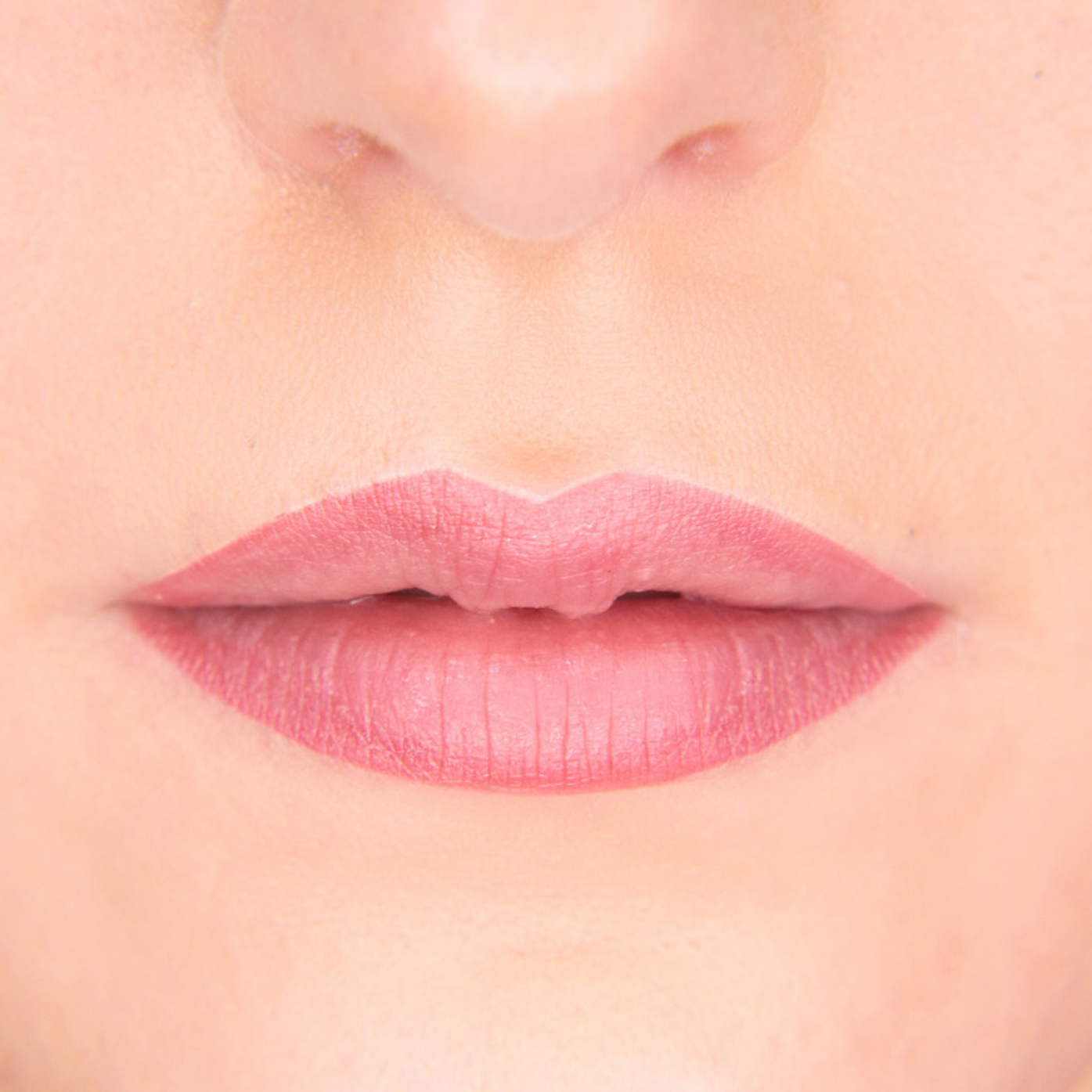 Eine Nahaufnahme der Lippen einer Frau mit rosa Lippenstift.
