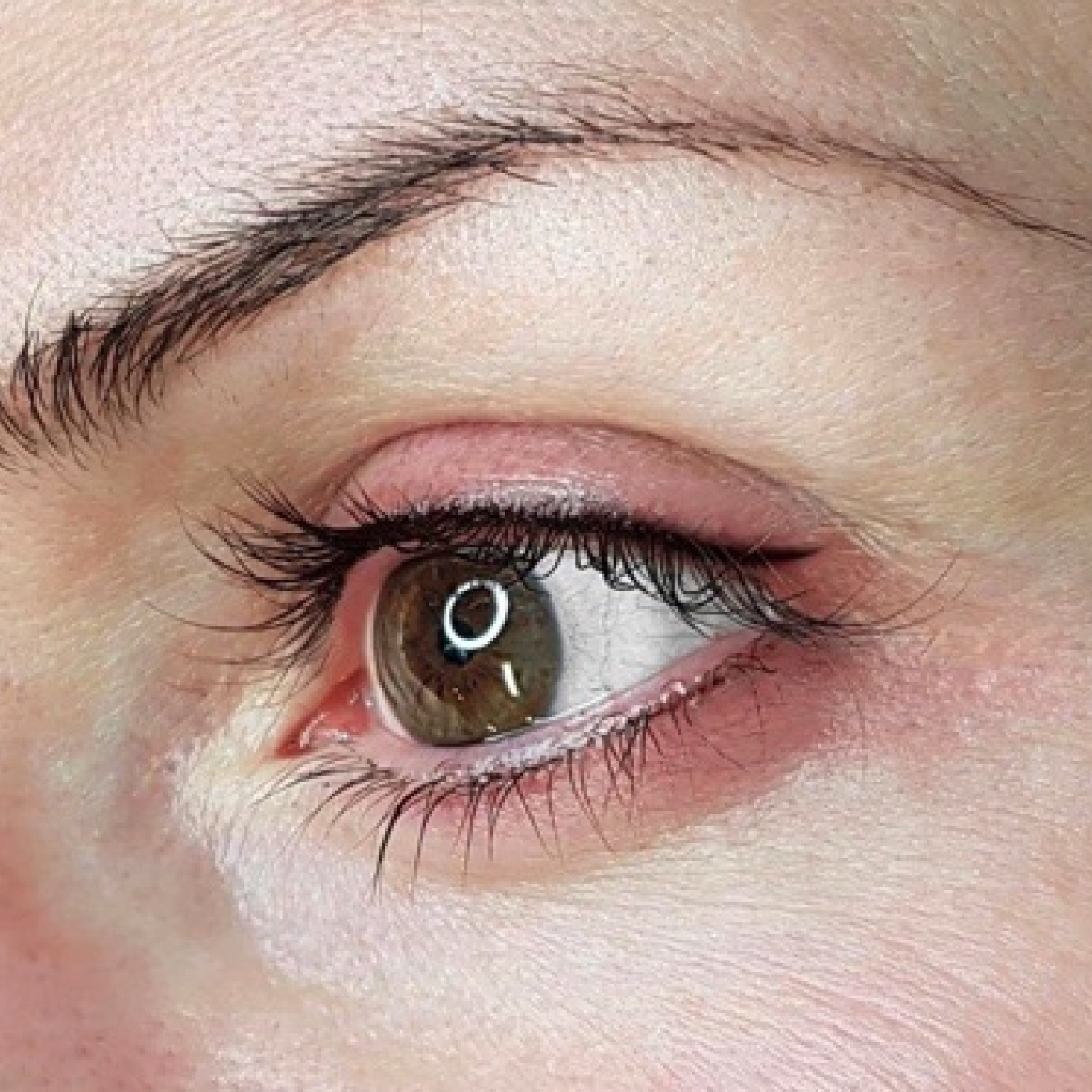 Eine Nahaufnahme des Auges einer Frau mit langen Wimpern.