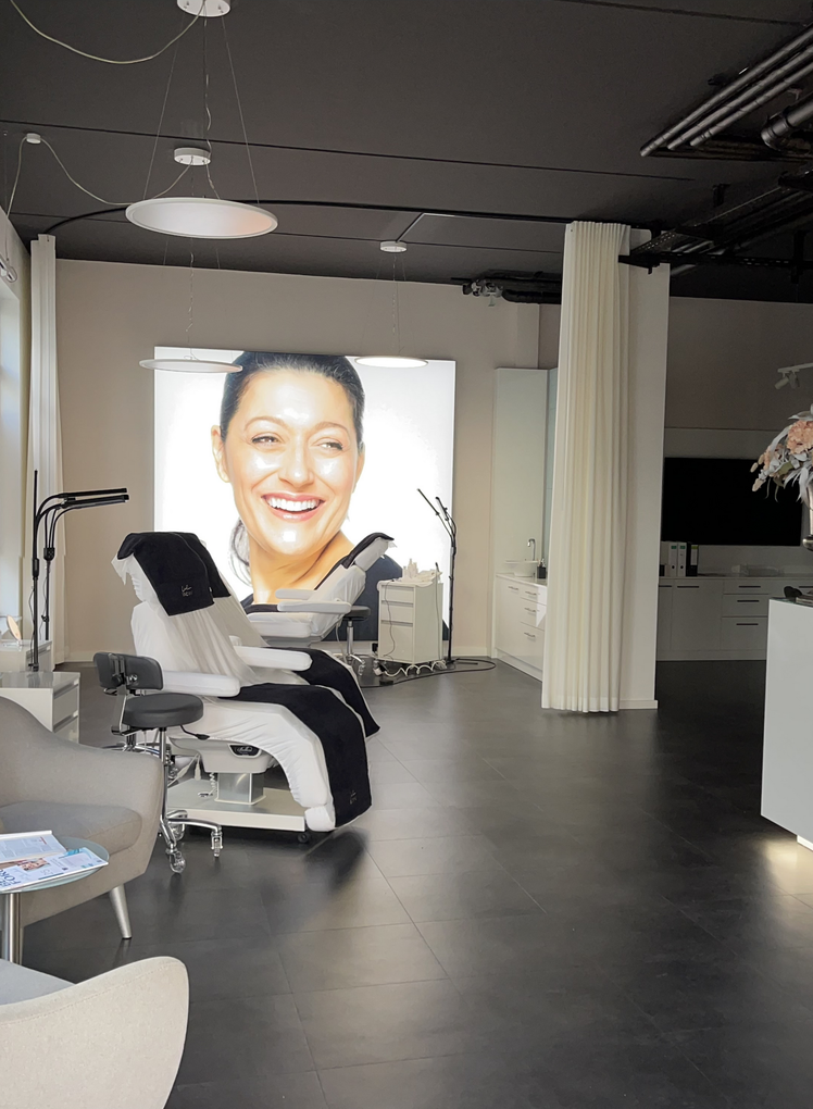 Ein Raum mit einem Stuhl und einem Bild einer Frau an der Wand