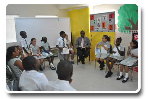 A group of children are sitting in a circle in front of a board with numbers on it