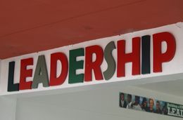 A sign that says leadership in red and green letters