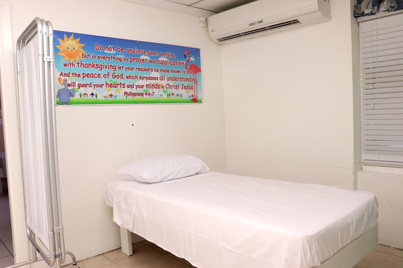 A hospital room with a bed and a sign on the wall