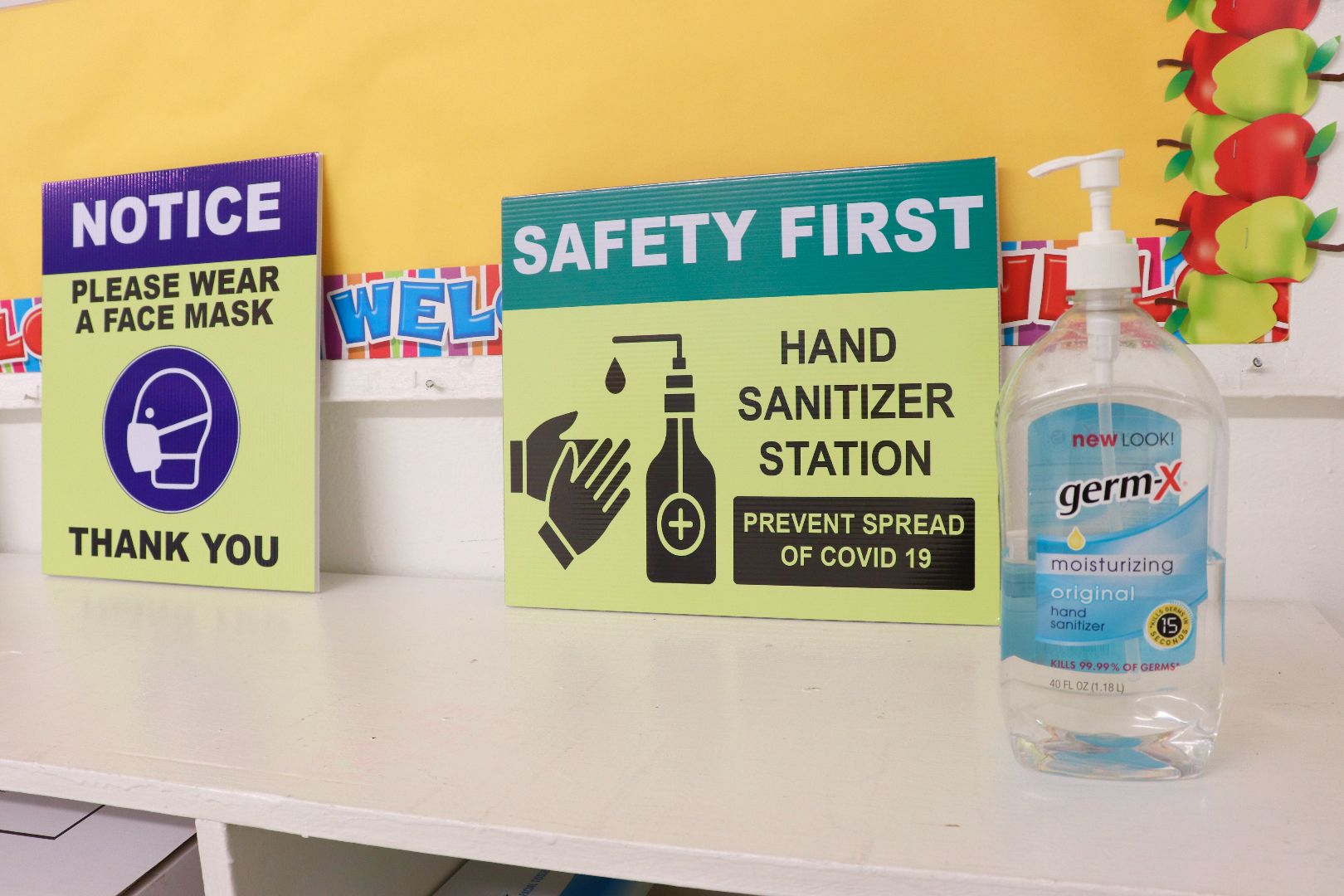 A sign that says safety first next to a bottle of hand sanitizer