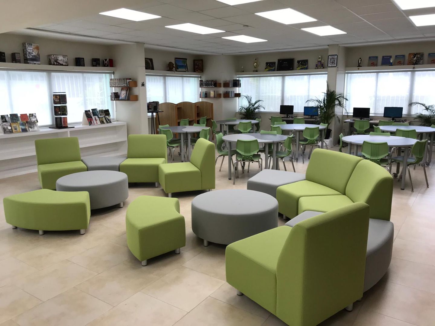 A large room with green chairs and tables
