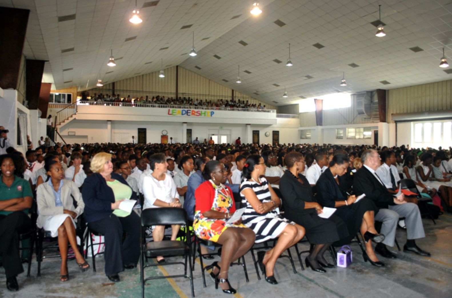 A large group of people are sitting in a large auditorium with a sign that says ' freedom ' on it