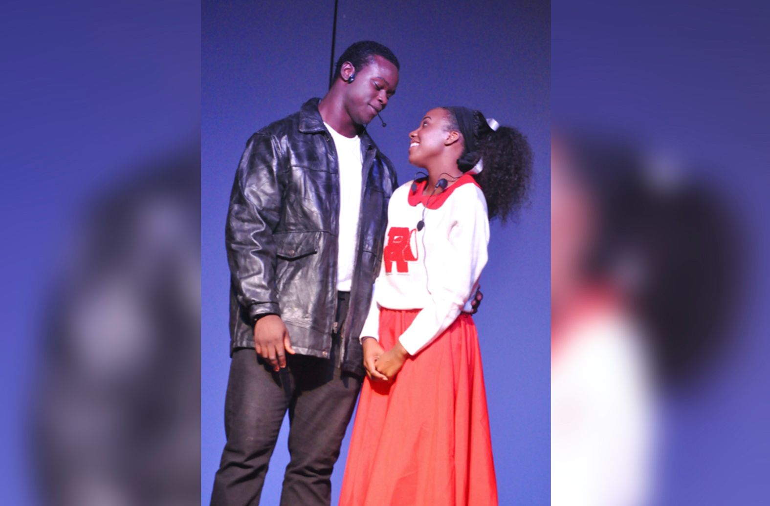 A man and a girl are looking at each other on a stage