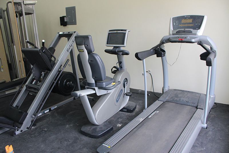 A treadmill and a recumbent bike are in a gym
