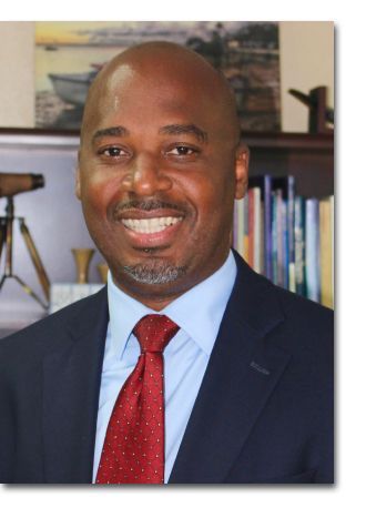 A man in a suit and tie is smiling for the camera