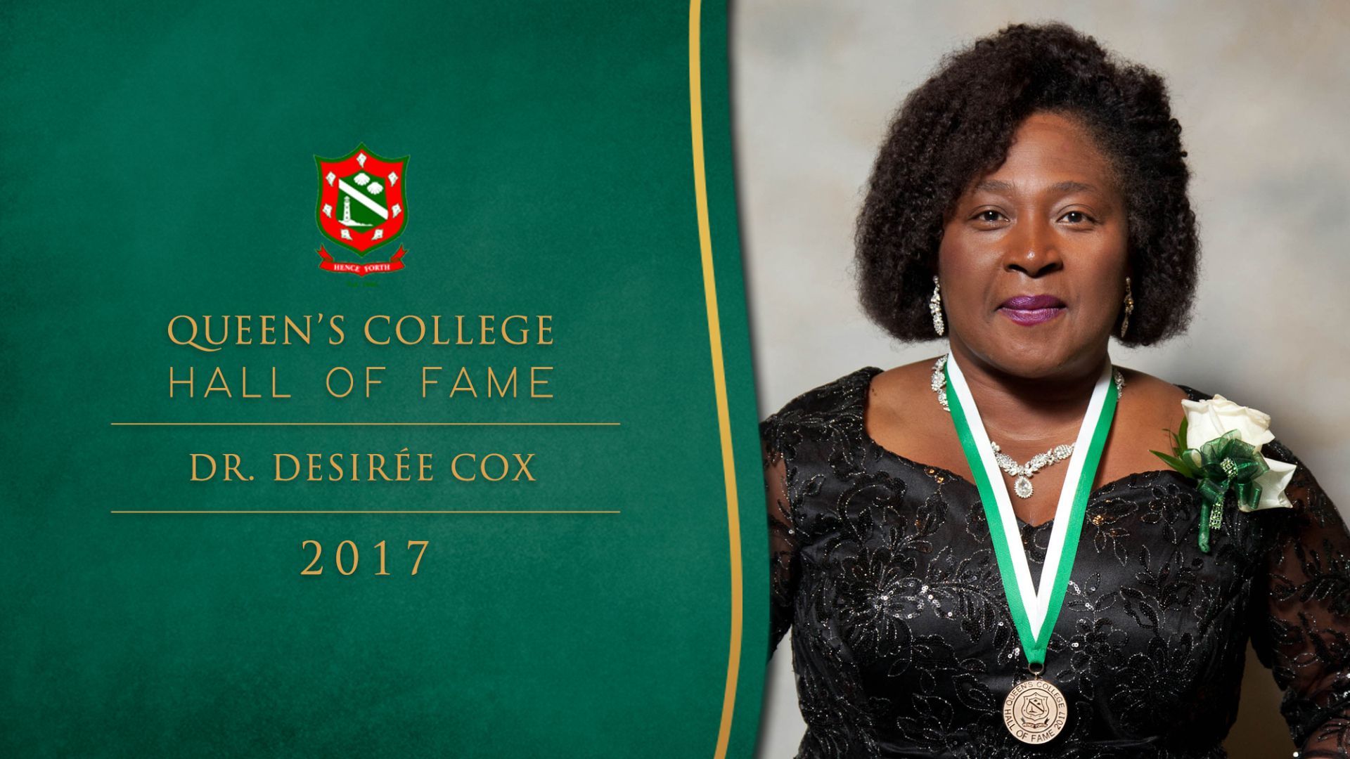 A woman with a medal around her neck is standing in front of a queens college banner