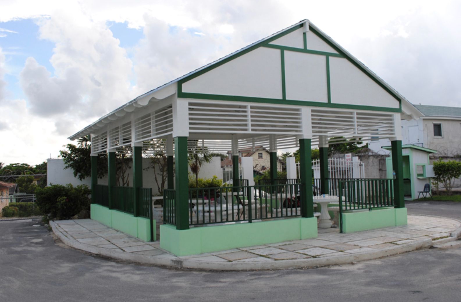 A white and green building with a fence around it