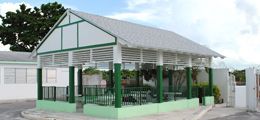 A white house with a green porch and a white roof