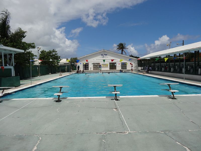 A large swimming pool with a white building in the background