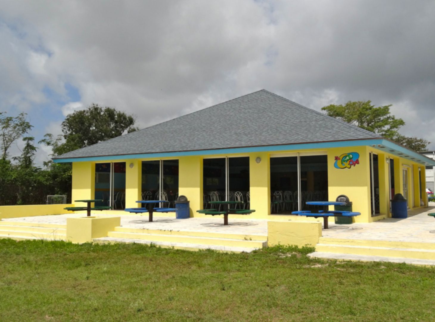 A yellow building with a blue roof and a sign that says ice cream