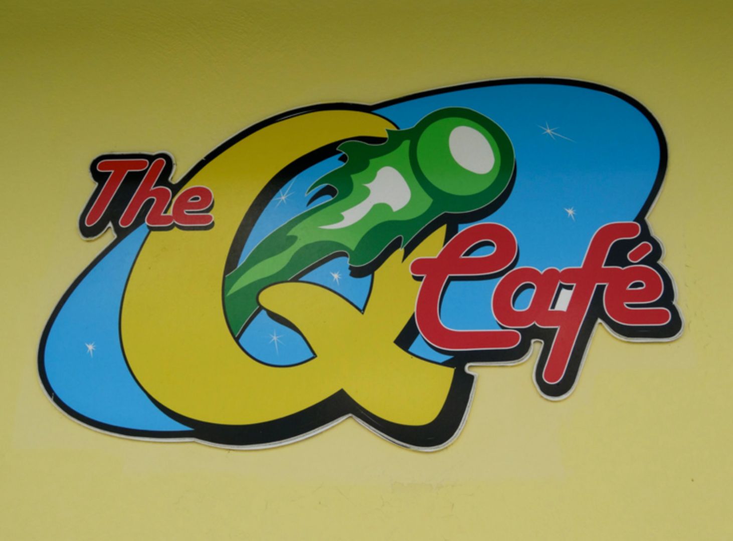 A colorful logo for the g cafe with a green jalapeno