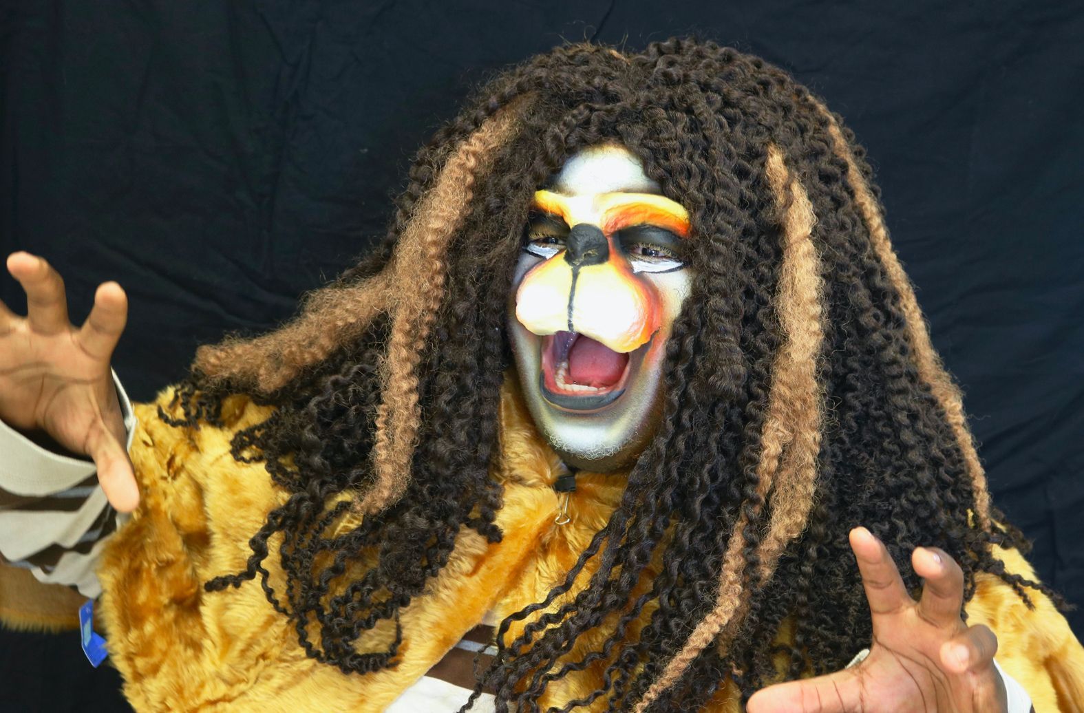 A person dressed in a lion costume with dreadlocks