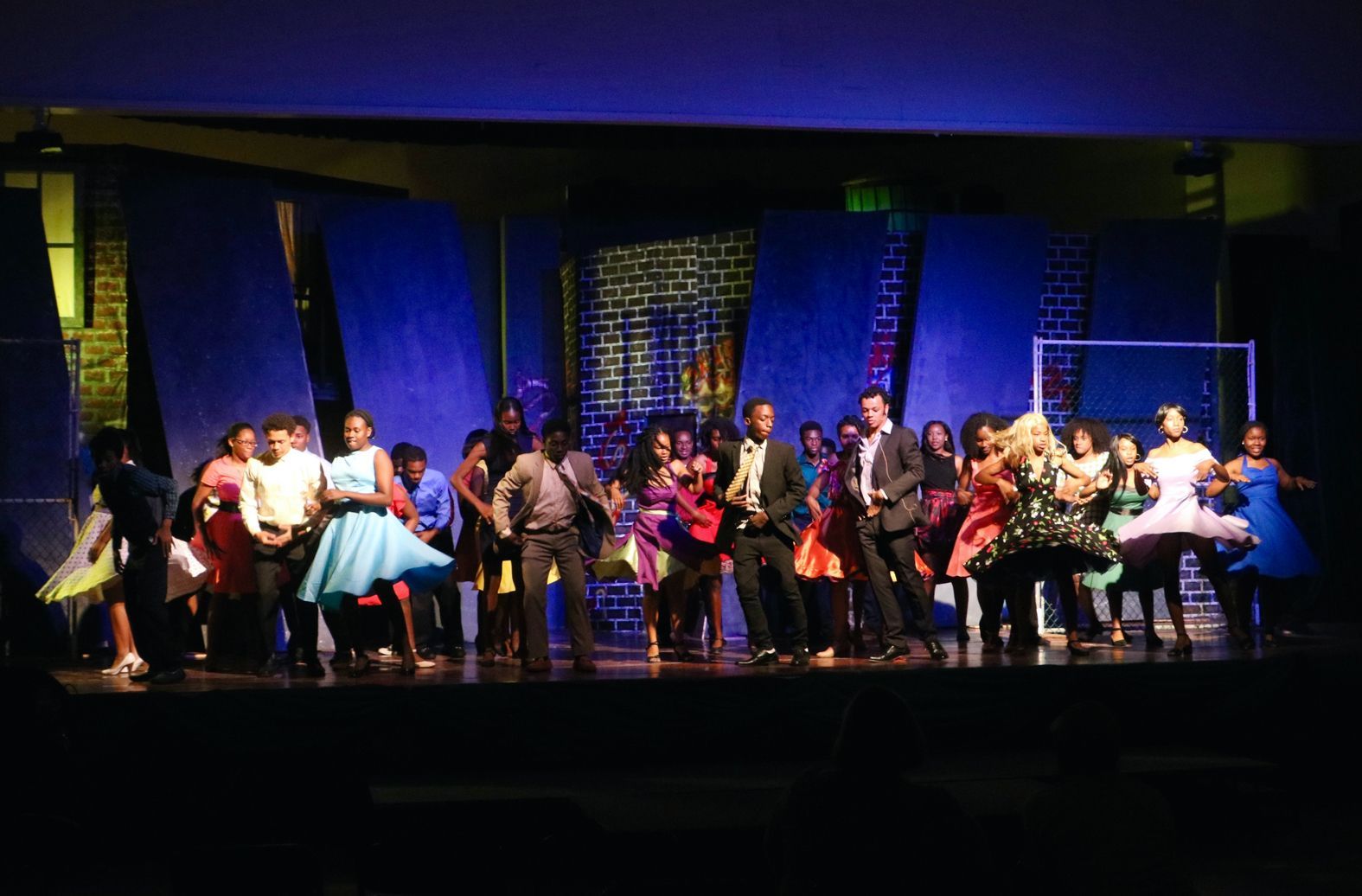 A large group of people are dancing on a stage