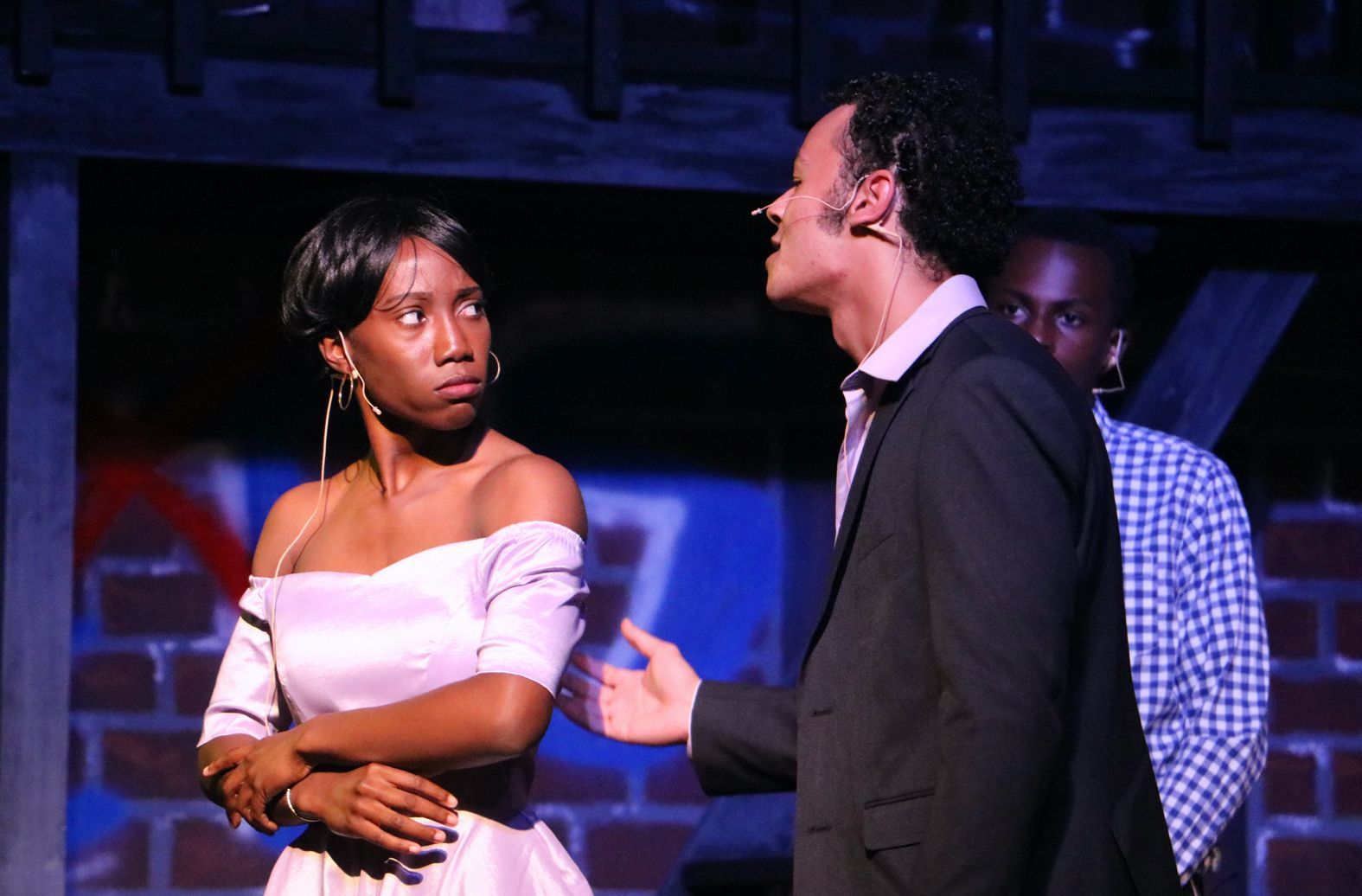 A man in a suit is talking to a woman in a white dress