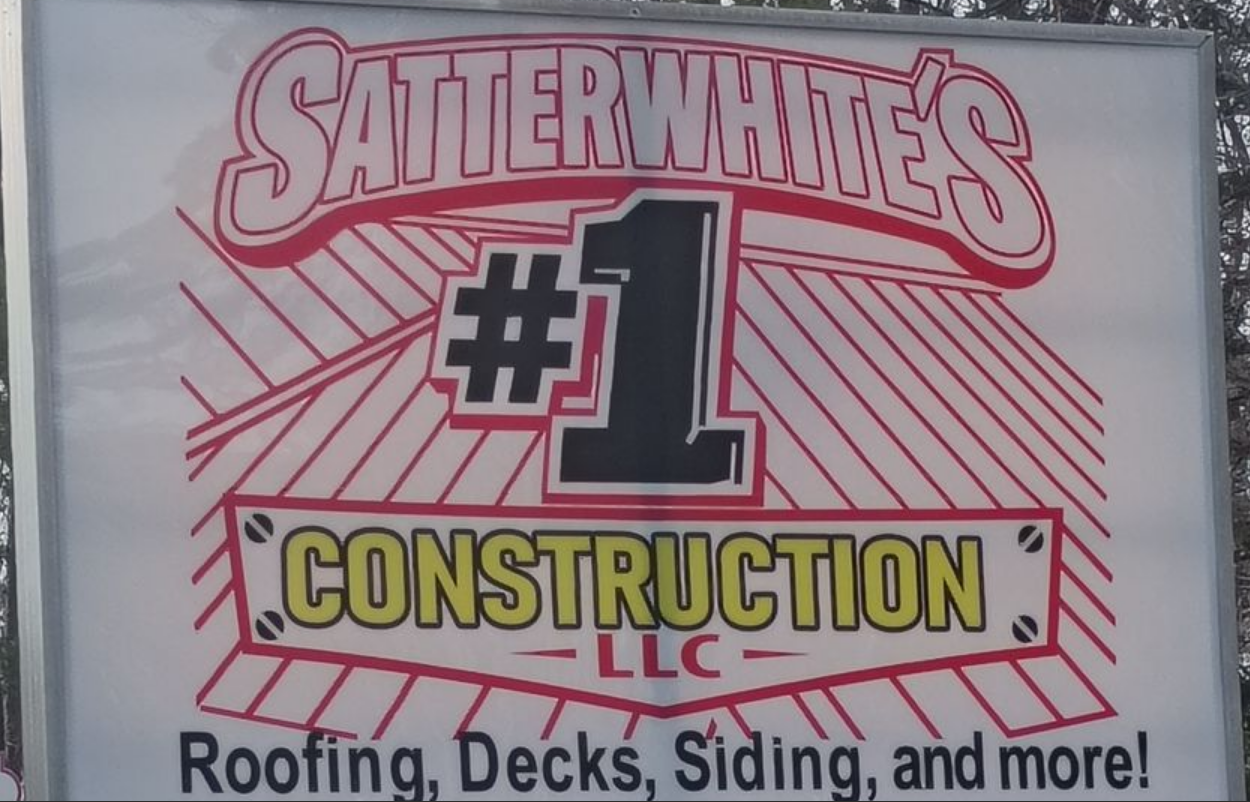 Satterwhite’s #1 Construction LLC sign with red and yellow lettering, advertising roofing, decks, siding, and more.