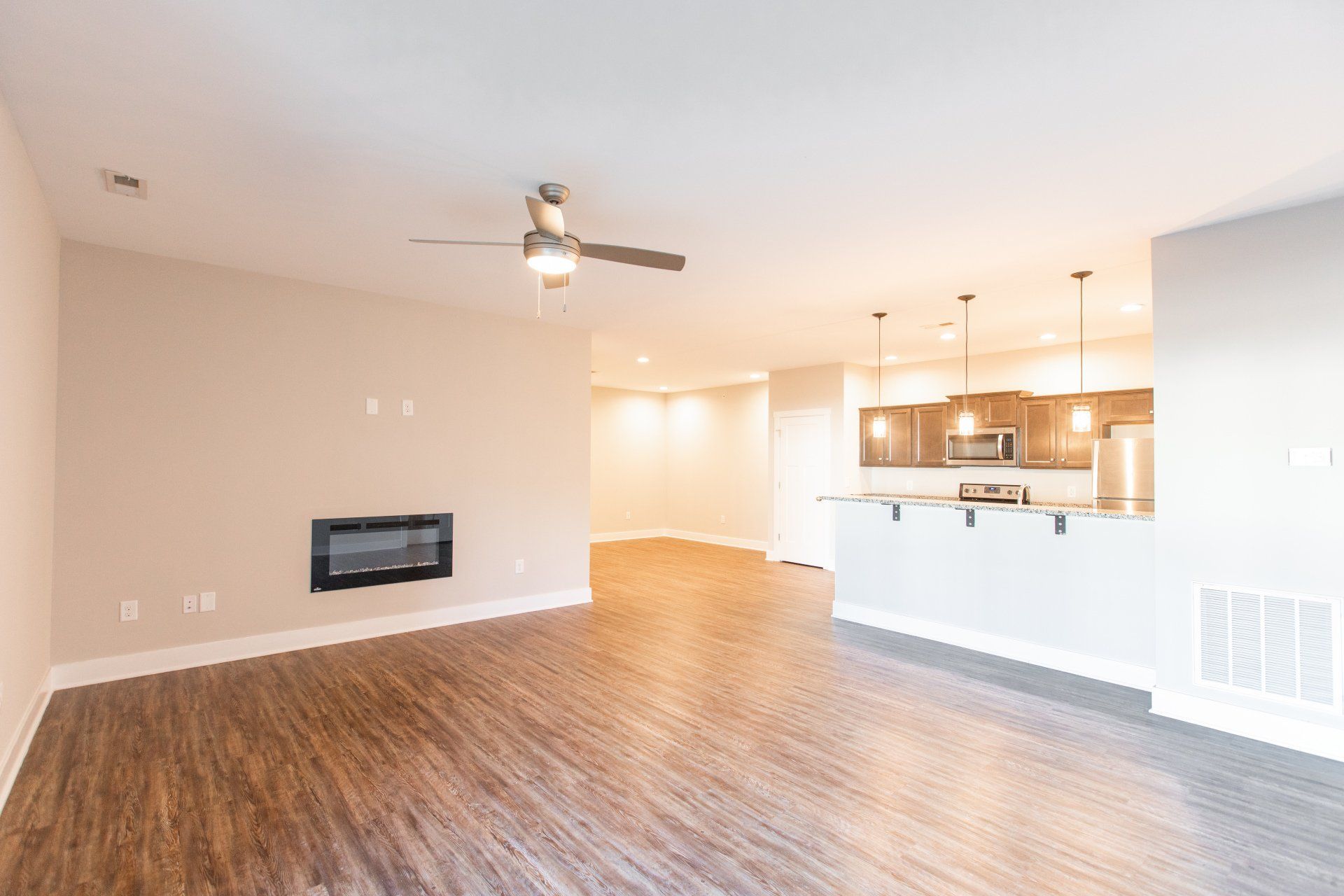 Living room with ceiling fan, fire place, and view of kitchen