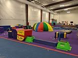 Indoor gymnasium with colorful foam obstacle course equipment and mats