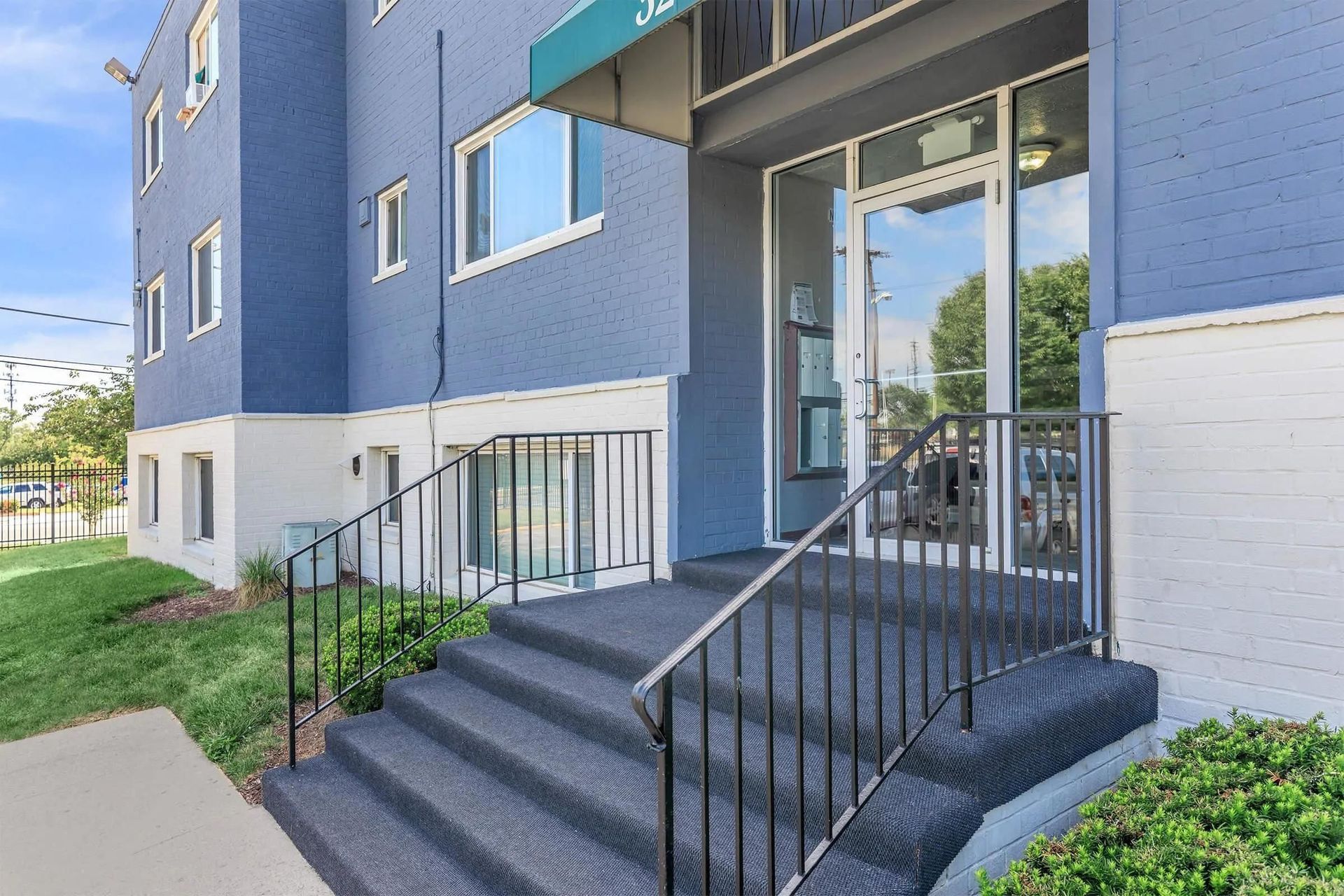 A blue building with stairs leading up to the entrance.