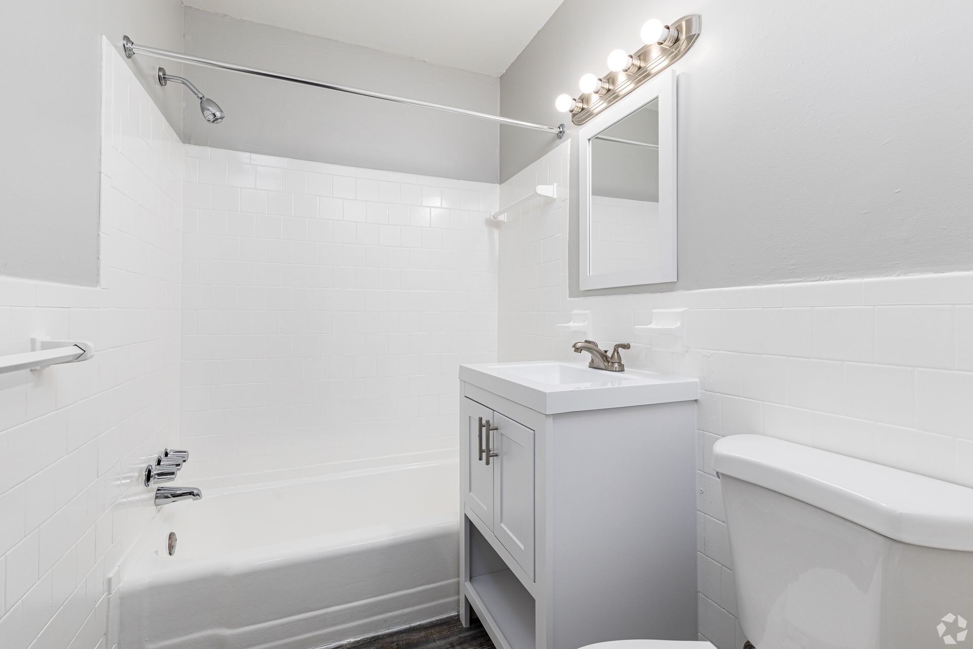 A bathroom with a sink , toilet , bathtub and mirror.