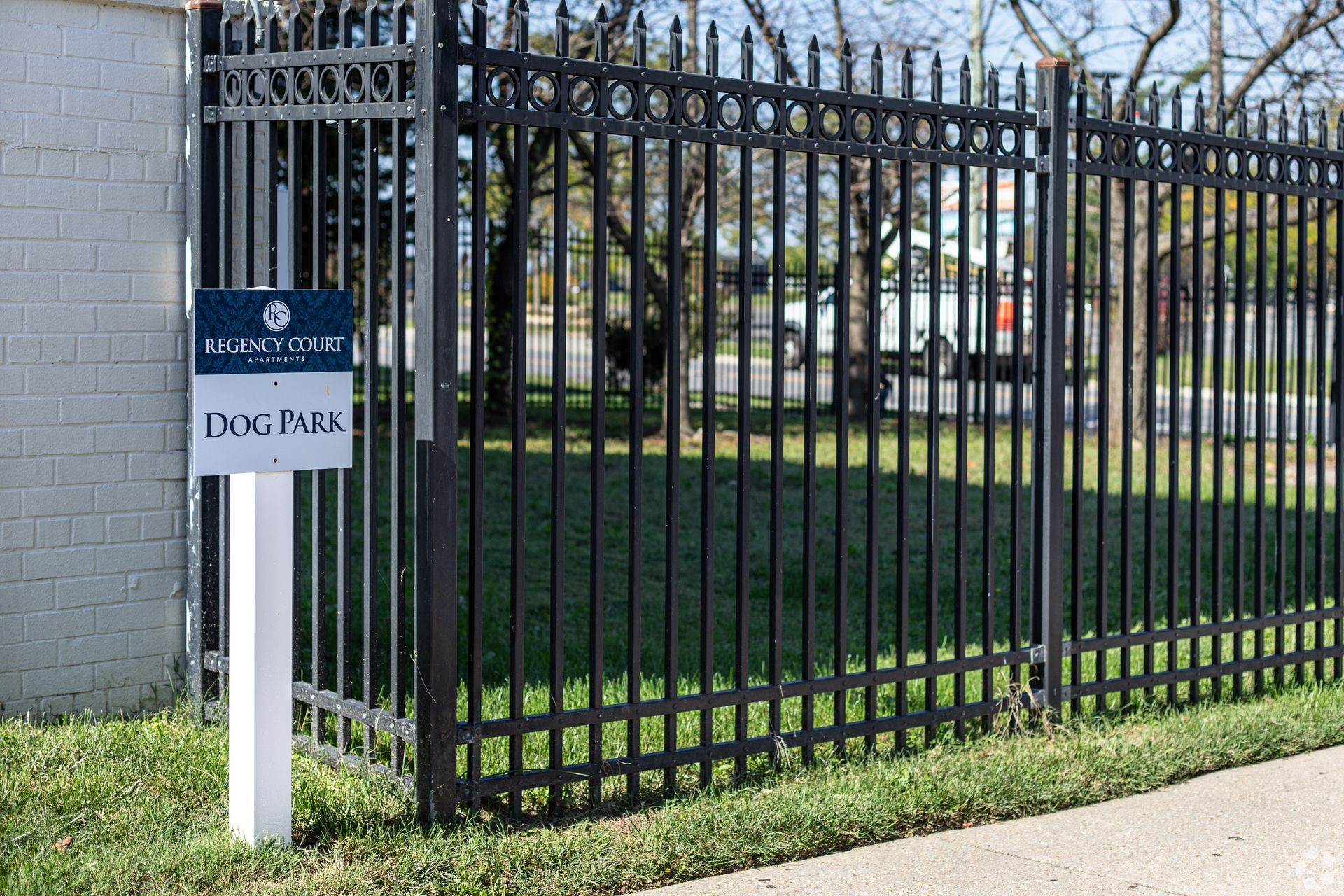 A fence with a sign in front of it that says dog park.