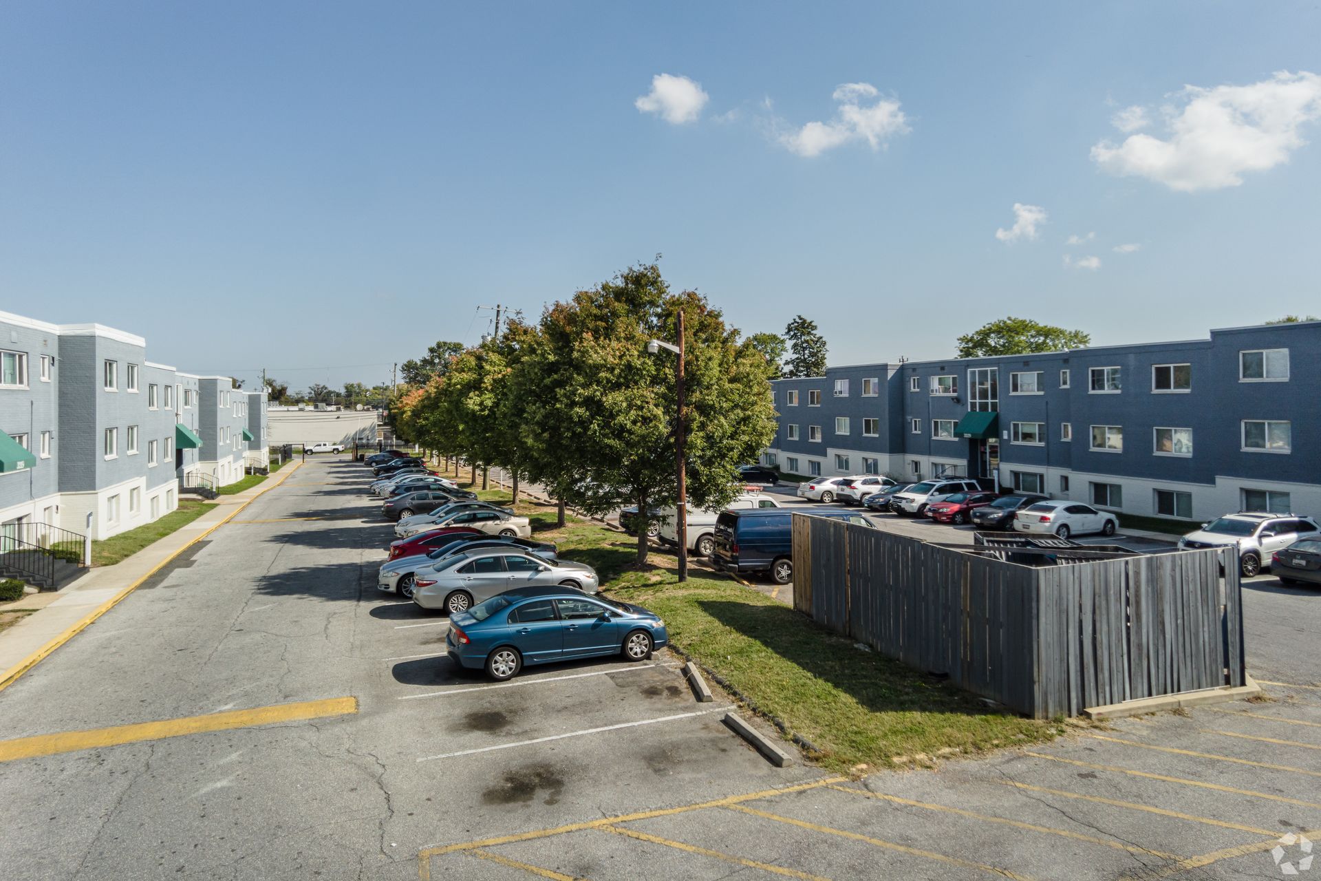 An aerial view of a parking lot with cars parked in front of a building.