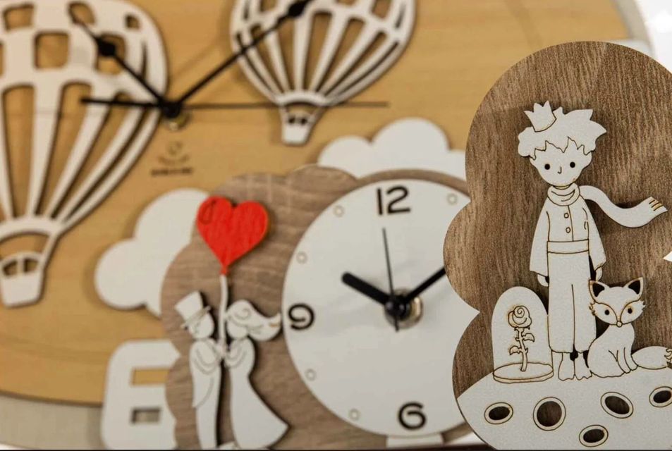 Orologio da parete decorativo in legno con illustrazione di mongolfiere e una ragazza che tiene in braccio una volpe.