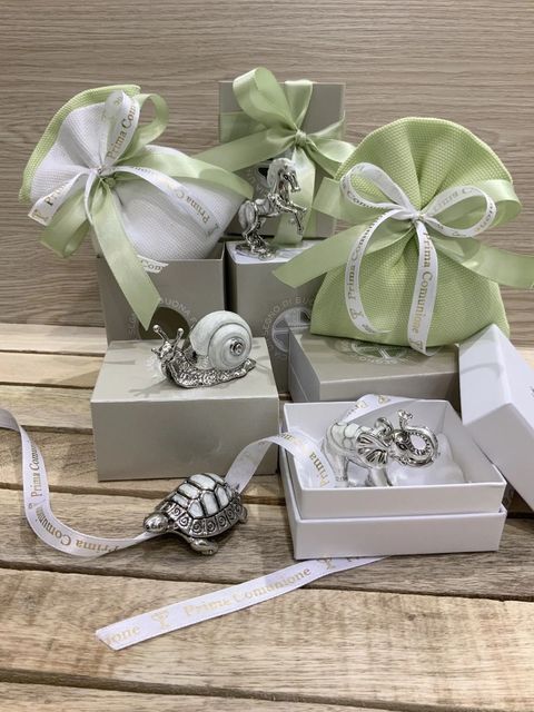 Scatoline regalo assortite, decorate con nastri verdi, bianchi e argentati, su una base di legno.