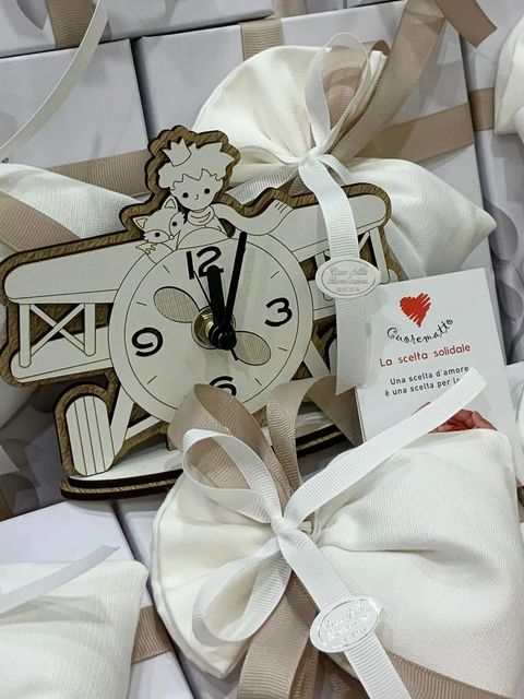 Orologio decorativo a forma di angelo, bomboniera con nastri beige e bigliettino di ringraziamento.
