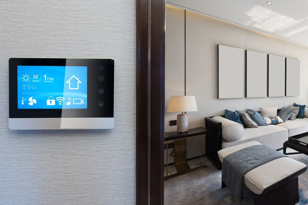 A living room with a couch and a thermostat on the wall.