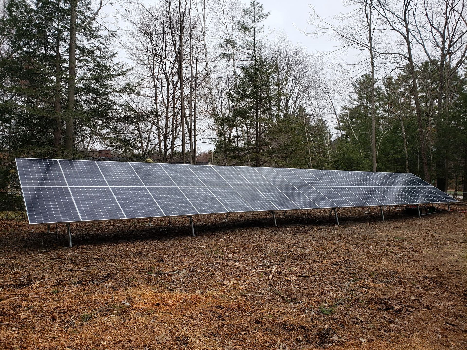 A large solar panel is sitting in the middle of a field.