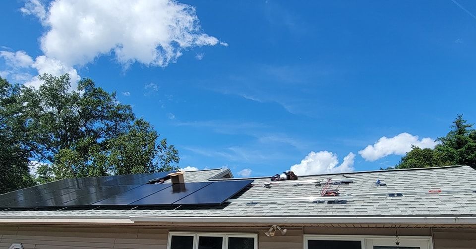 A solar panel is being installed on the roof of a house.