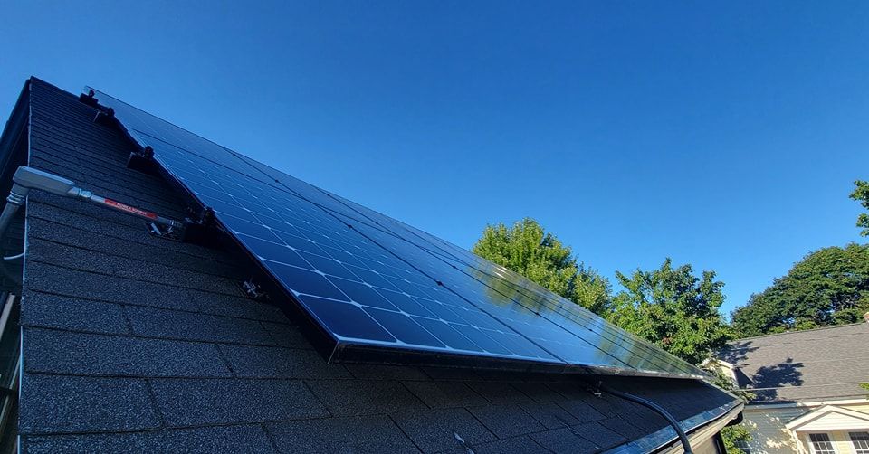 A row of solar panels on the roof of a house.