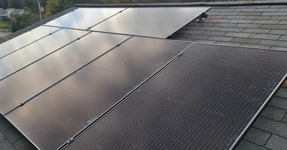 A row of solar panels sitting on top of a roof.