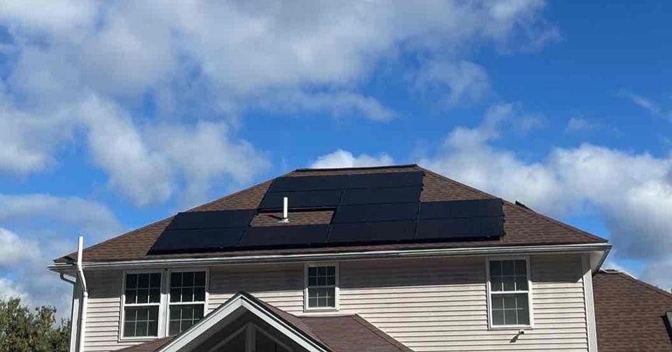 A house with solar panels on the roof on a sunny day.
