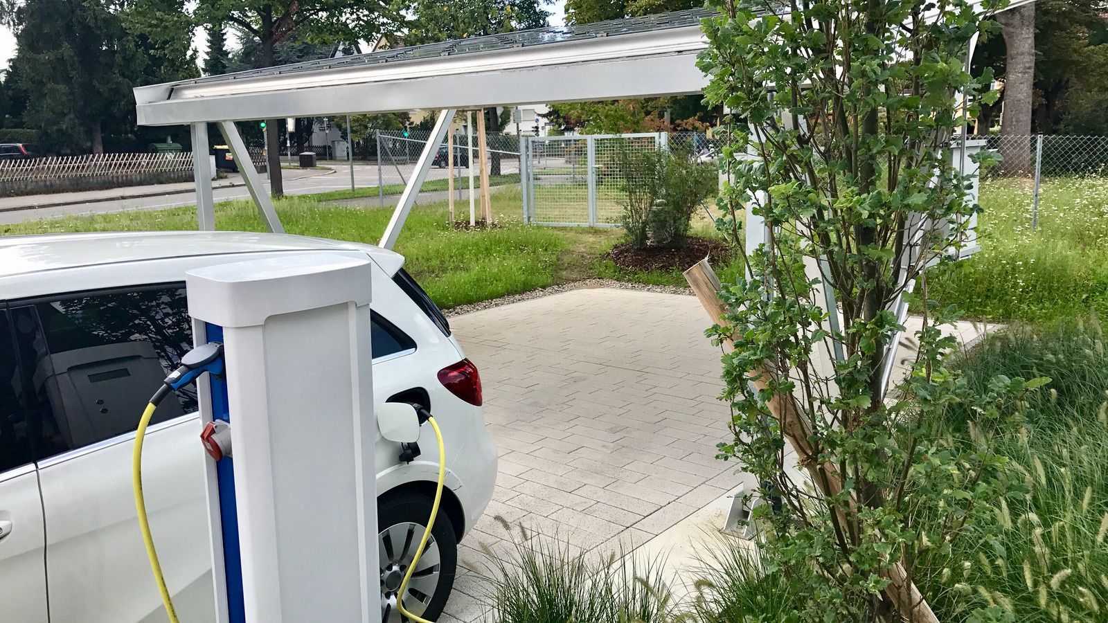 Two electric cars are being charged at a charging station.