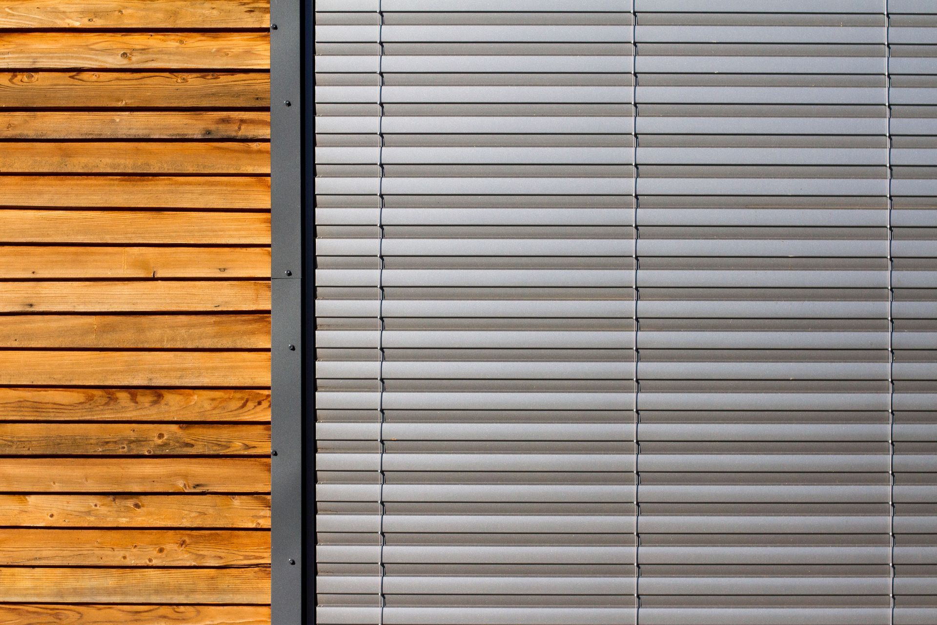 A close up of a wooden wall and a window with blinds.