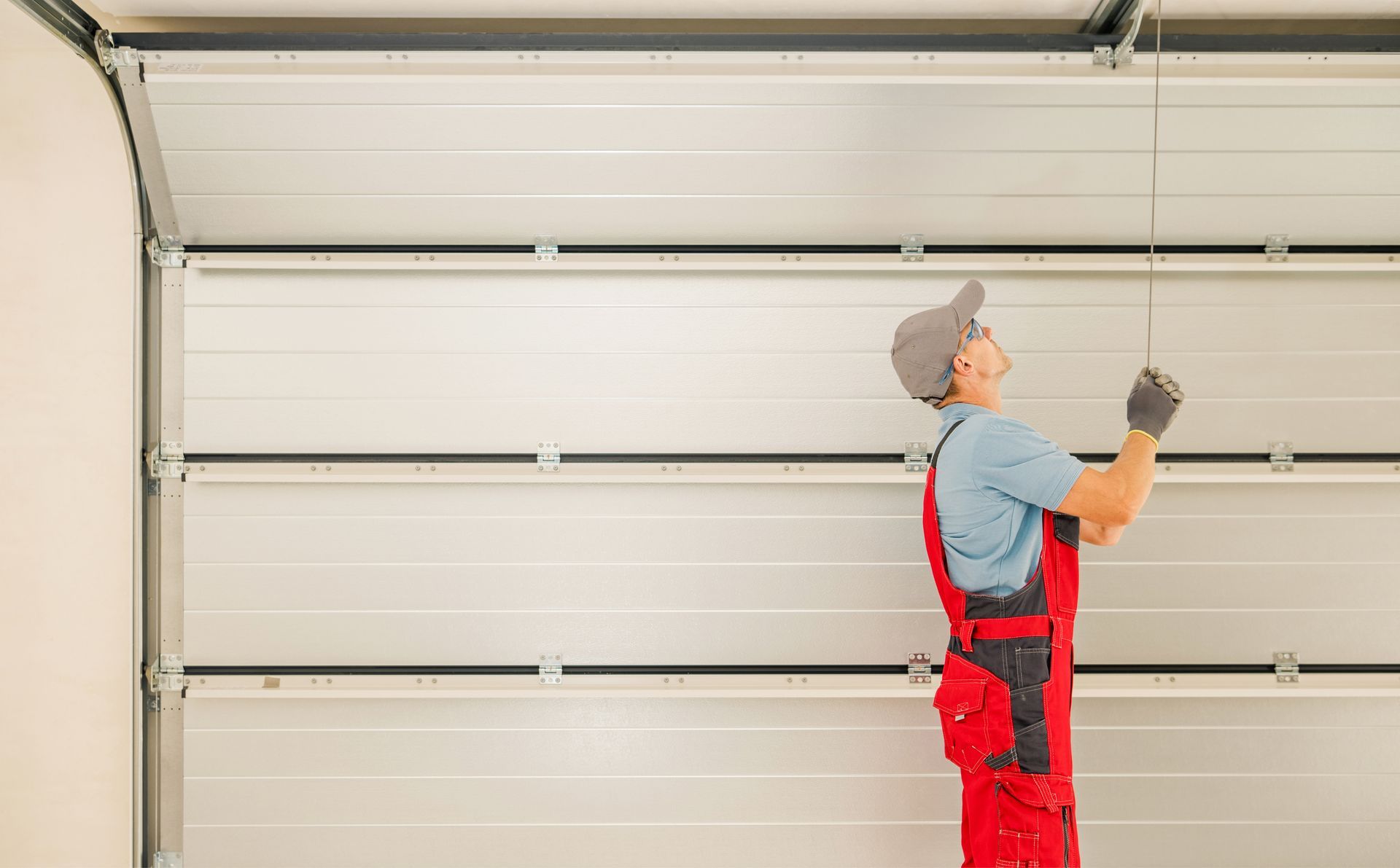A man is installing a garage door in a garage.