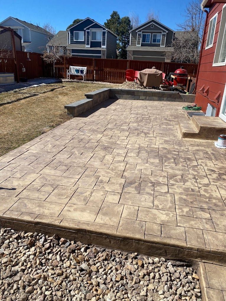 A patio with a fire pit in the backyard of a house.