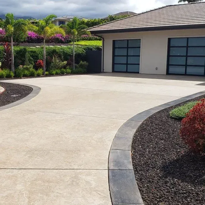 A driveway leading to a house with two garage doors