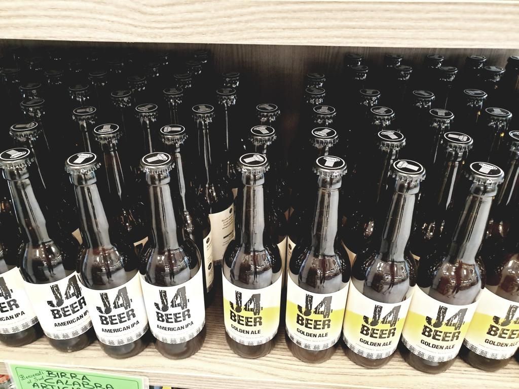 Molte bottiglie di birra j14 sono allineate su uno scaffale