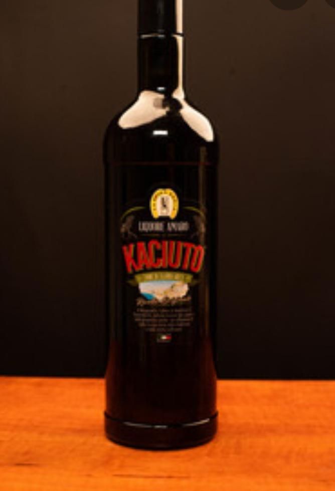 Una bottiglia di kachuto è appoggiata su un tavolo di legno