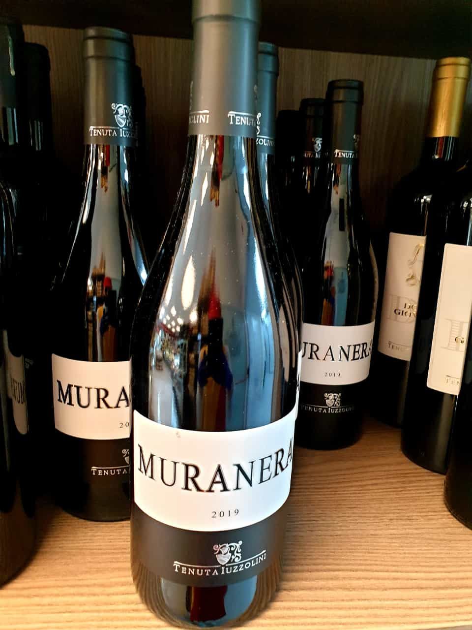 Una bottiglia di vino muraner è circondata da altre bottiglie di vino