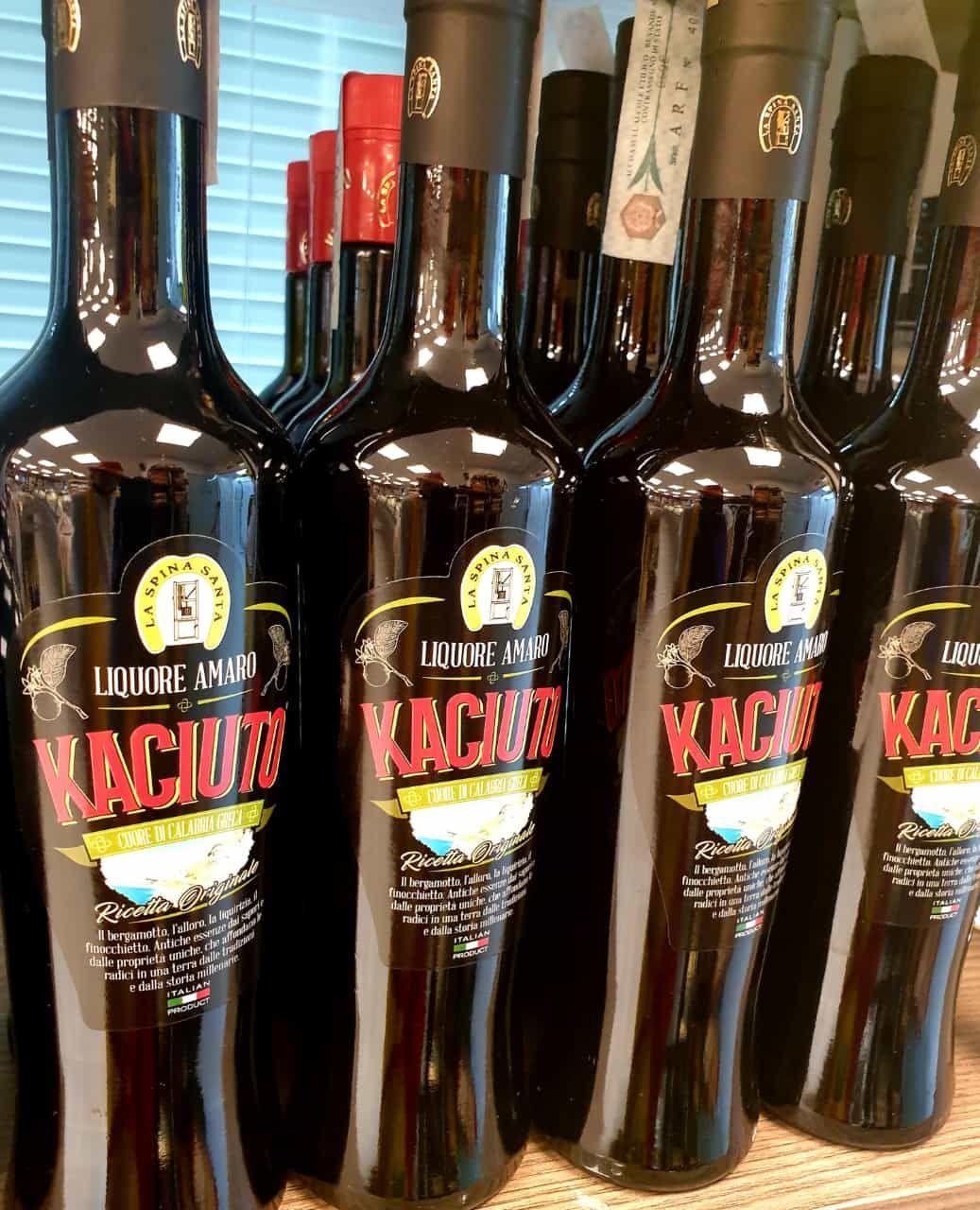 Una fila di bottiglie di kahlua sono allineate su uno scaffale